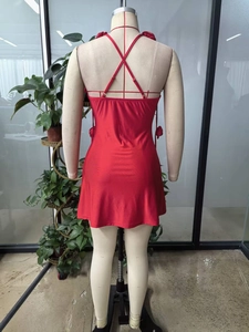 Detail of red backless mini dress featuring 3D handmade floral accents and crossed straps