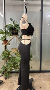 Détail de la robe noire découpée avec bordure en plumes sur le bustier sans bretelles