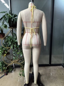 Back view of yellow backless halter top with adjustable tie-up ribbons on an office mannequin
