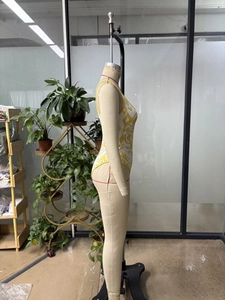 Side profile of a slim fit bodysuit with yellow baroque print on a female mannequin