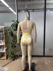Detailed back view of one-piece swimsuit featuring yellow baroque floral prints and open back