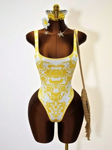 White one-piece swimsuit with yellow baroque print and elegant U-neckline on a mannequin