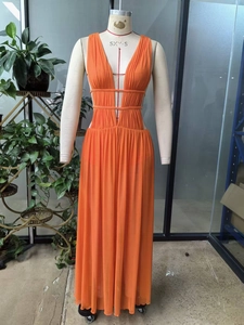 Detail shot of bright orange V-neck maxi dress with waist cutouts and pleated chiffon fabric