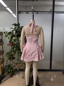 Detailansicht des rosa Jacquard-Kleids mit einer großen Satinschleife auf dem Rücken