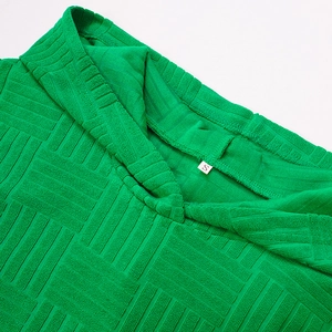 Vue macro du col du sweat à capuche vert avec une texture géométrique gaufrée 3D