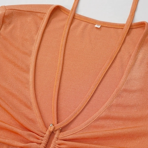 Détail d'une robe en maille corail montrant le col en V, les fronces et l'étiquette S