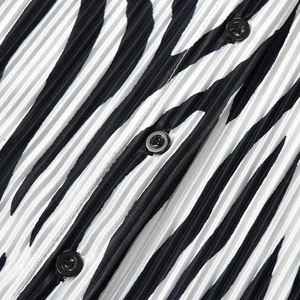 Detail of zebra print pleated shirt with black buttons and vertical fabric texture