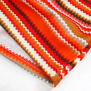 Dettaglio delle strisce colorate e trama a nido d'ape sul vestito con scollo a V e schiena