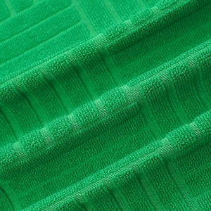Détail du tissu jacquard vert émeraude avec texture bouclée douce et motif 3D carré