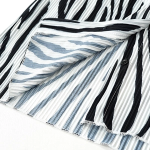 Detail of pleated zebra print shirt with delicate texture and black button closure