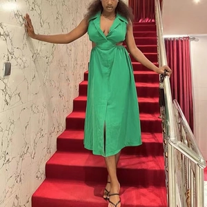 Détail d'une robe midi verte sans manches avec découpes à la taille et fente avant