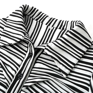 Close-up of black and white vertical striped shirt texture with size S label and black button