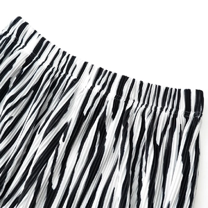 Detail of high-elastic waistband and pleated texture on zebra print wide-leg trousers