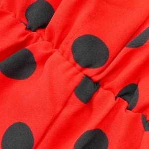 Détail de la combinaison rouge à pois noirs et texture de la taille élastiquée