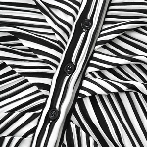 Detail of black and white striped ribbed fabric with three black buttons on the placket