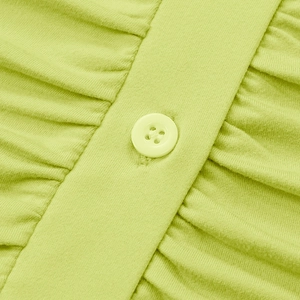 Macro view of knit dress pleats and matching lime green button closure detail