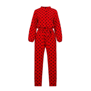 Détail de la combinaison rouge à pois noirs avec manches longues et lien à la taille