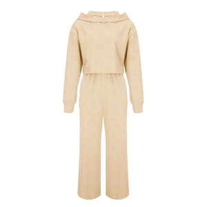 Détail d'un ensemble beige texturé avec sweat à capuche et pantalon large taille haute