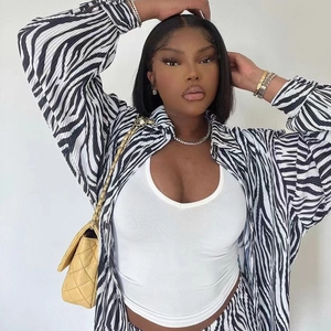 Women's pleated zebra print long sleeve shirt with white tank top and yellow chain bag