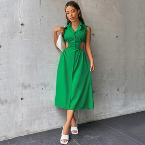 Détail de la robe vert émeraude avec découpe à la taille et détails plissés ajustés