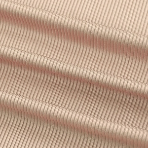 Close-up of the light pink ribbed knit fabric texture showing vertical patterns