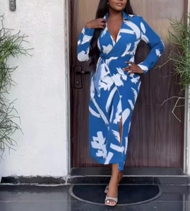 Detail of dark blue wrap dress featuring white abstract prints and a waist tie closure