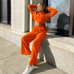 Gros plan sur le tissu gaufré orange vif de l'ensemble haut court et pantalon large