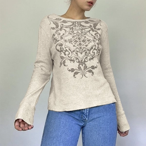Close-up of beige waffle knit long sleeve top with vintage print and crew neck