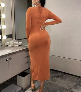 Détail de la robe moulante rouge rouille avec dos nu et fermeture par nœud au cou