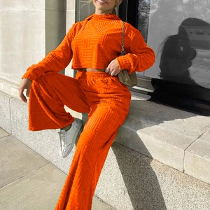 Détail d'un ensemble deux pièces orange avec sweat à capuche et maille gaufrée