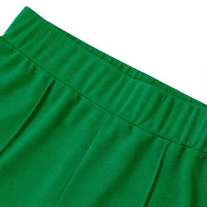 Detail of emerald green high waist elastic waistband with pleated fabric texture