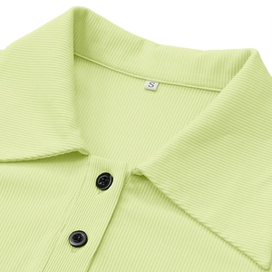 Close-up of light green ribbed knit dress featuring polo collar and black buttons