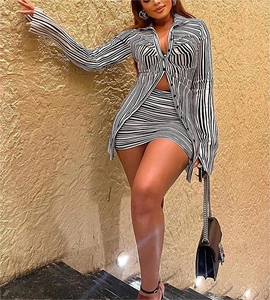 Detail of black and white striped two-piece set with long sleeve shirt and mini skirt
