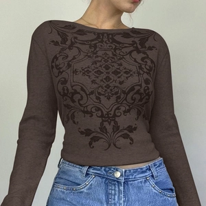 Detailed view of women's waffle knit top featuring vintage print and slim fit long sleeves