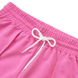 Dettaglio dei pantaloncini rosa con elastico in vita e coulisse bianca con fiocco