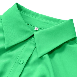 Detailed macro view of the green polo collar with a matching button and size S tag