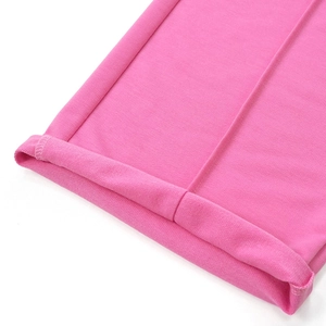 Dettaglio dei pantaloni larghi rosa con orlo arrotolato e cucitura centrale verticale