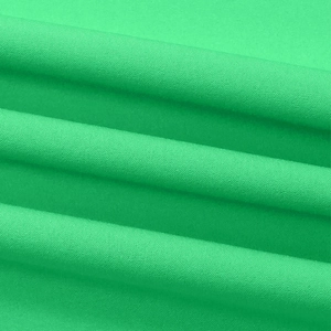 Detailed macro view of the bright green woven fabric with smooth wave-like fold texture