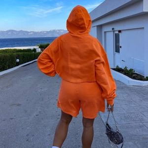 Damen Sportset mit hellem orangefarbenem Oversize-Kapuzenpullover und Kordelzug-Shorts