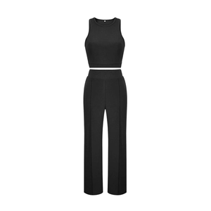 Detail of black sleeveless crop top and high waist wide leg trousers with center seam