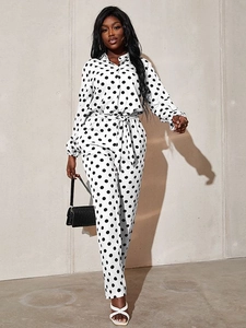 Combinaison femme à pois noirs et blancs avec manches longues et ceinture à nouer
