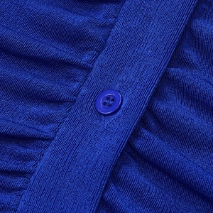 Macro detail of royal blue knit dress featuring a resin button and ruched texture
