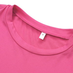 Détail du col rond rose rouge et de l'étiquette taille S sur le haut en tricot