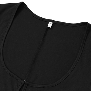 Detail of the deep U-neckline on a black long-sleeve jumpsuit with clean stitching