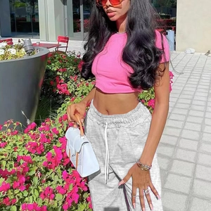Completo casual da donna con crop top rosa e pantaloni sportivi grigi con coulisse
