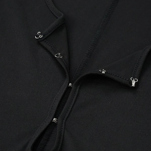 Detail view of the metal hook-and-eye closure on a black knitted long sleeve jumpsuit