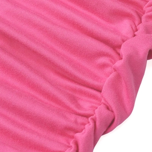 Gros plan du tissu tricoté rouge rose montrant la texture froncée et les coutures en maille