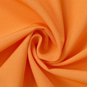 Nahaufnahme von leuchtend orangefarbenem Stoff mit weichen Falten und matter Textur