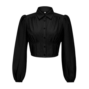 Detail der schwarzen Crop-Bluse mit Laternenärmeln, Korsett-Taille und vorderen Knöpfen