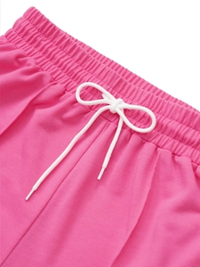 Détail de la taille élastique rose vif avec cordon blanc et coutures renforcées
